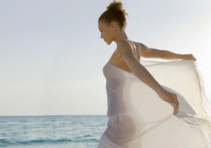 Un femme sur la plage en maillot avec un voile